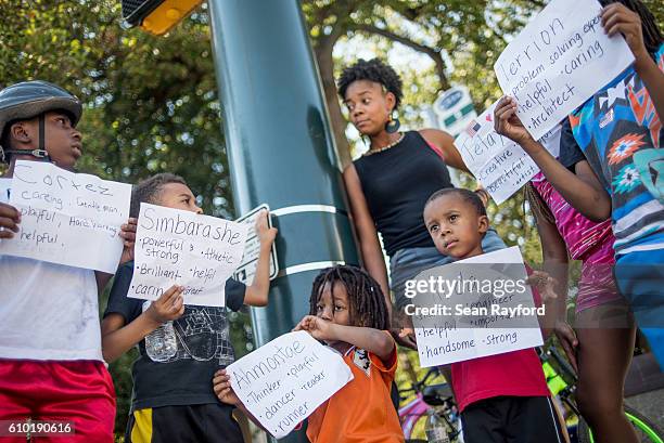 Children hold protest signs on a street corner as a march approaches an intersection September 24, 2016 in uptown Charlotte, North Carolina. Protests...