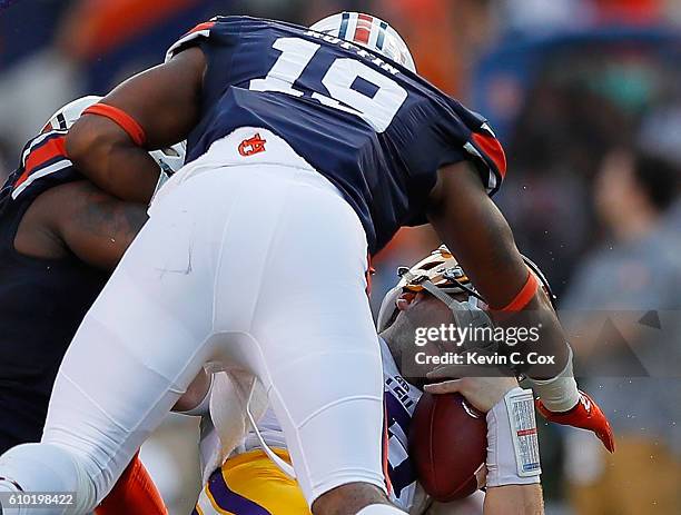 Danny Etling of the LSU Tigers loses his helmet after this hit by Tre' Williams and Nick Ruffin of the Auburn Tigers at Jordan-Hare Stadium on...