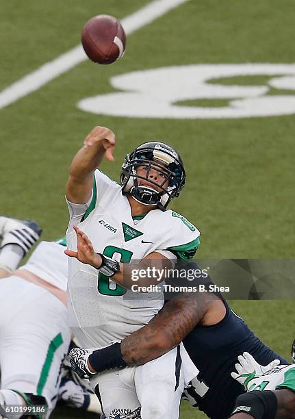 Quarterback Mason Fine of the North Texas Mean Green is hit by defensive end Jae Phan of the Rice Owls in the first half at Rice Stadium on September...