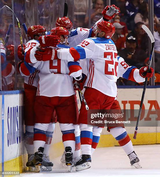 Nikita Kucherov of Team Russia is congratulated by his teammates after scoring a second period goal against Team Canada at the semifinal game during...