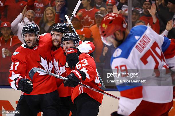 Andrei Markov of Team Russia skates away as Brad Marchand of Team Canada is congratulated by his teammates Patrice Bergeron and Alex Pietrangelo...