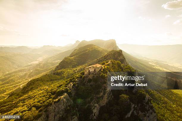 aerial view of a beautiful church on top of mountain with stunning summits on sunset light in the catalan pyrenees. - catalan stock pictures, royalty-free photos & images