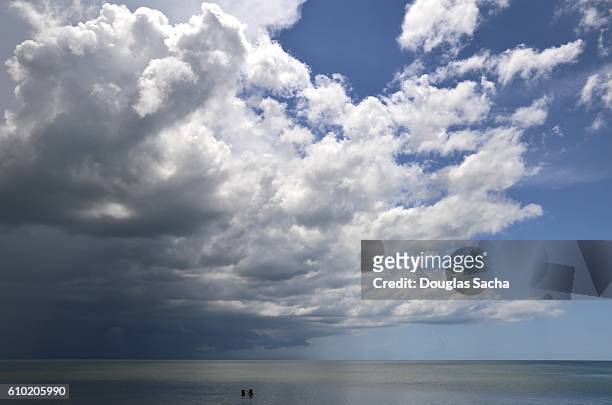 passing storm over the distant water - hurricane season stock pictures, royalty-free photos & images