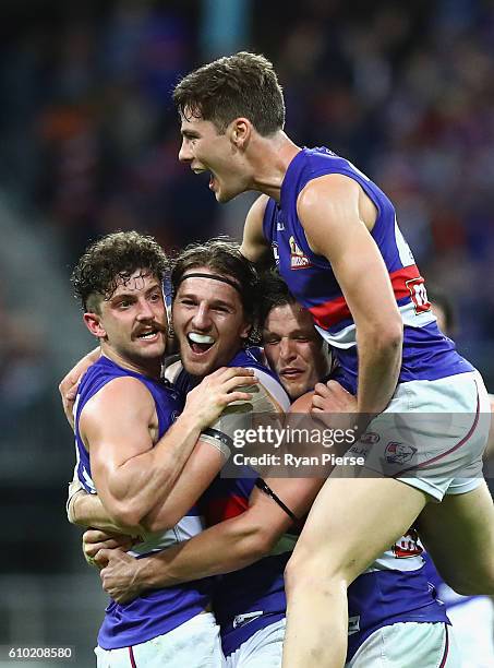 Tom Liberatore, Marcus Bontempelli, Dale Morris and Josh Dunkley of the Bulldogs celebrate victory after the AFL First Preliminary Final match...