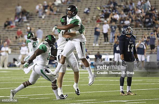 Linebacker Brandon Garner of the North Texas Mean and teammates celebrate defeating the Rice Owls in double overtime at Rice Stadium on September 24,...