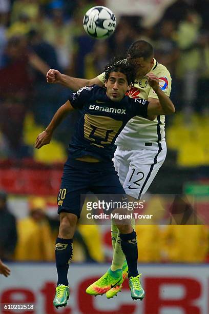Pablo Aguilar of America jumps for the ball with Matias Britos of Pumas during the 11th round match between America and Pumas UNAM as part of the...