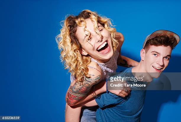 young man and woman laughing and smiling - man blue background stockfoto's en -beelden
