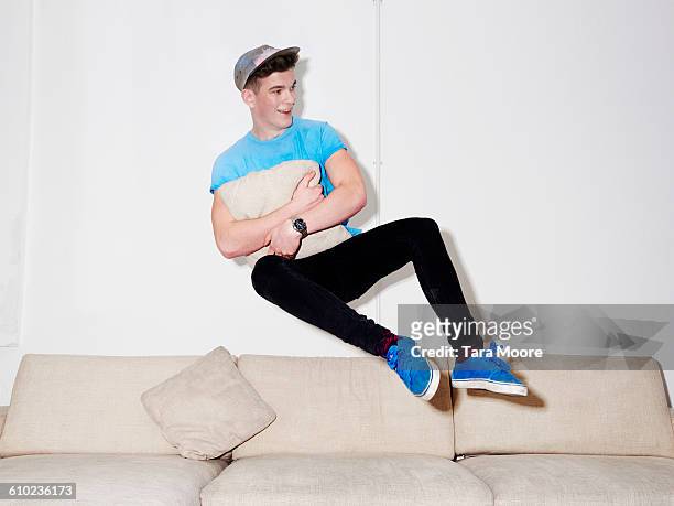 man jumping on sofa - in de lucht zwevend man stockfoto's en -beelden