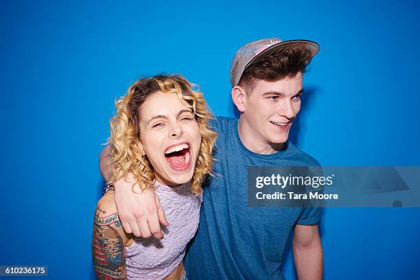 young man and woman laughing and smiling - white t shirt studio stock pictures, royalty-free photos & images