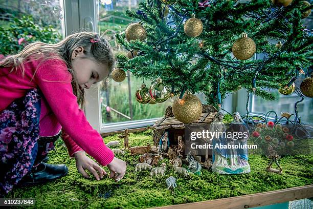 ragazza di quattro giocando con statuette di natività, europa - natività foto e immagini stock