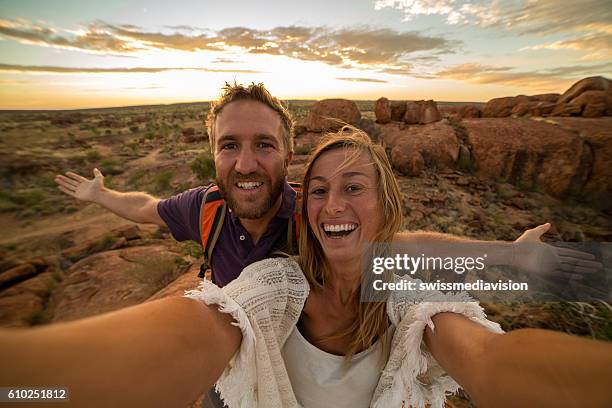 young couple take selfie portrait with spectacular landscape at sunrise - female bush photos stockfoto's en -beelden