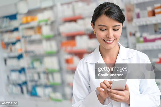 pharmacist using app on a smart phone - pharmacist phone stock pictures, royalty-free photos & images