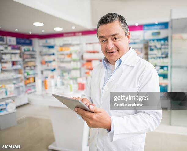 man working at a pharmacy using a tablet computer - pharmacy delivery stock pictures, royalty-free photos & images