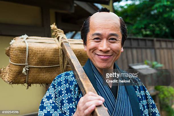 portrait of smiling japanese peasant with burden - 17th century man stock pictures, royalty-free photos & images