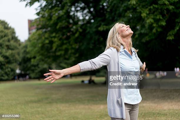 adult woman enjoying her time at the park - woman with arms outstretched stock pictures, royalty-free photos & images
