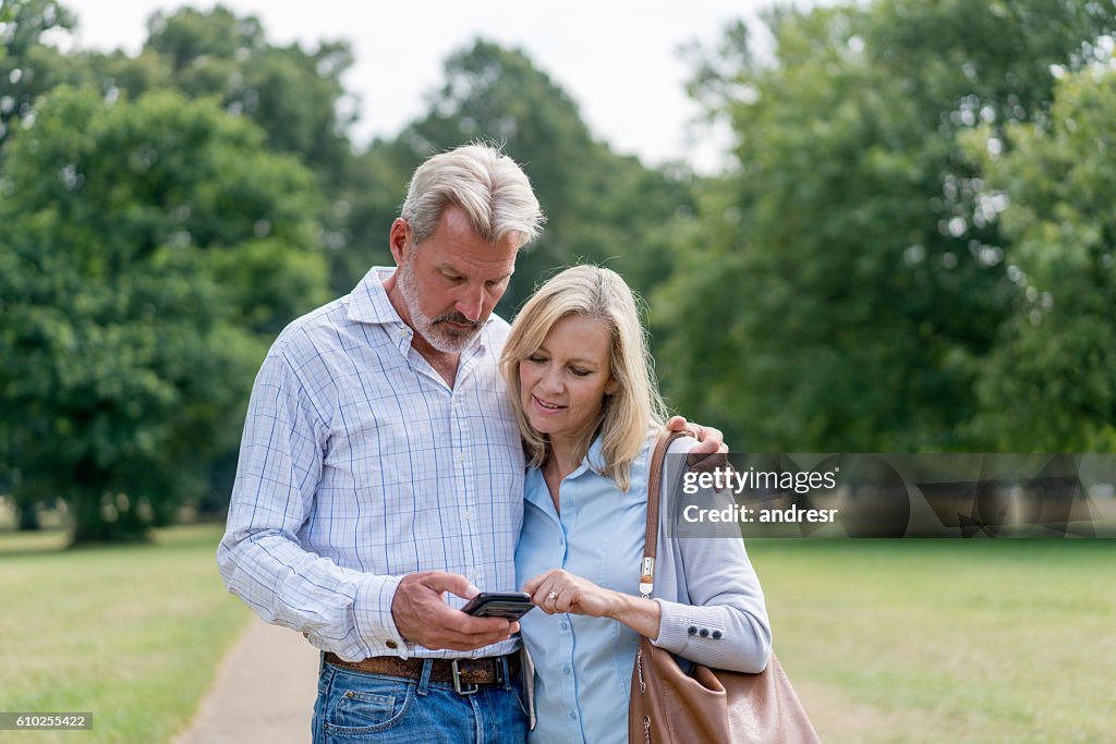 Couple using their cell phone at the park