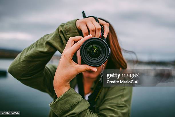 young woman using dslr camera - fotoreporter stockfoto's en -beelden