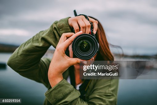 Jovem mulher usando DSLR câmara Jovem mulher usando DSLR câmara