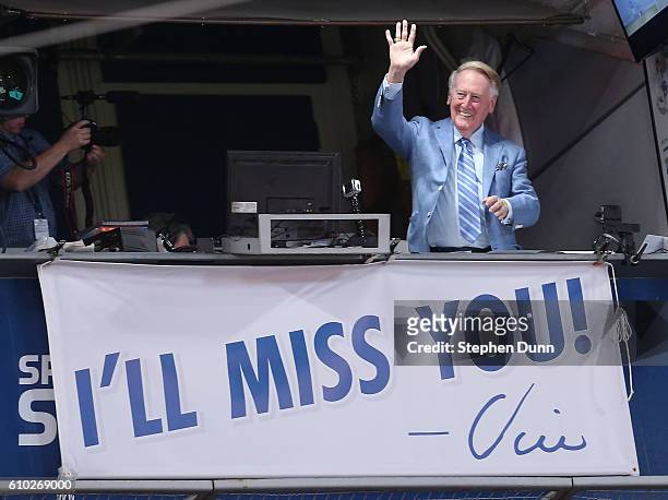 Los Angeles Dodgers broadcaster Vin Scully waves to the crowd after leading in the singing of Take Me Out to the Ball Game during the seventh inning...
