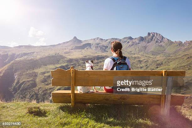 solo traveller and dog looking at spitzmeilen, flums, switzerland - woman dog bench stock pictures, royalty-free photos & images