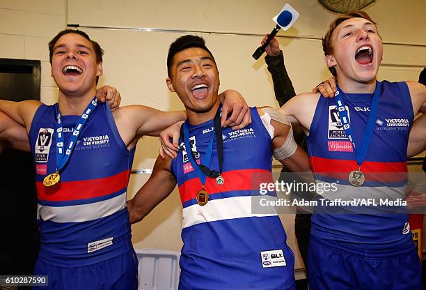 Lukas Webb, Lin Jong and Bailey Dale of the Bulldogs sing the team song during the VFL Grand Final match between Footscray Bulldogs and Casey...