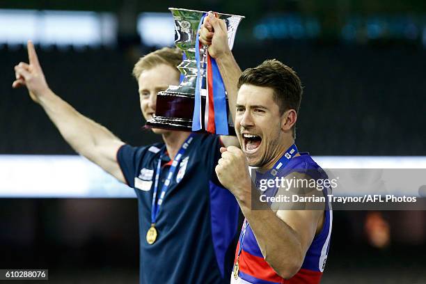 Footscray coach Ashley Hansen and captain Jordan Russell of the Bulldogs hold up the premiership cup after the VFL Grand Final match between the...