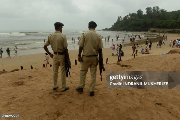 Indian policemen stand guard as they watch over tourists visiting Baga beach in Goa on September 24, 2016. - India is hosting the 8th BRICS summit in...