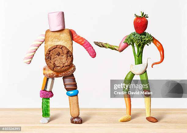 fat sweet man and thin vegetable man - chocolate bean stock pictures, royalty-free photos & images