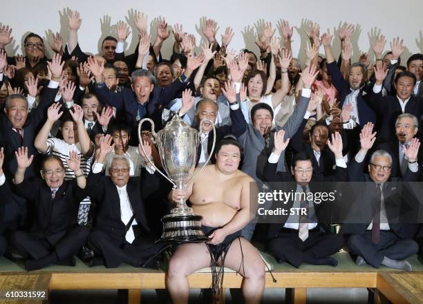 Ozeki-ranked wrester Goeido , holding the champion trophy of the Autumn Grand Sumo Tournament, celebrates his victory with supporters in Tokyo on...