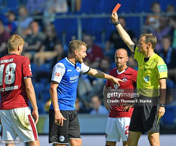 Referee Markus Schmidt shoews the yellow red card to Sebastian Schuppan of Bielefeld during the Second Bundesliga match between DSC Arminia Bielefeld...