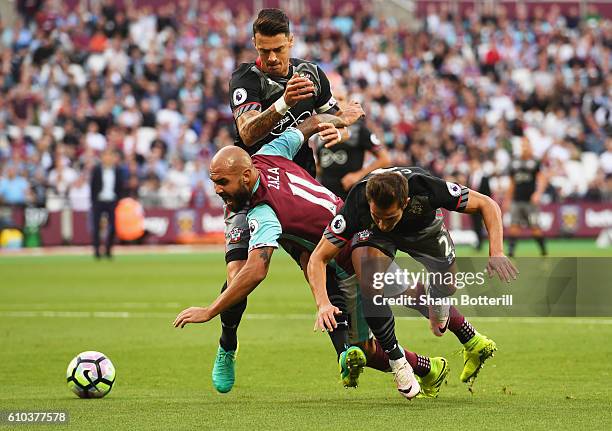 Simone Zaza of West Ham United tangles with Jose Fonte and Cedric Soares of Southampton during the Premier League match between West Ham United and...