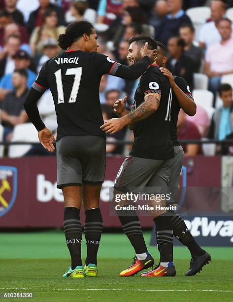 Charlie Austin of Southampton celebrates with Virgil van Dijk as he scores their first goal during the Premier League match between West Ham United...