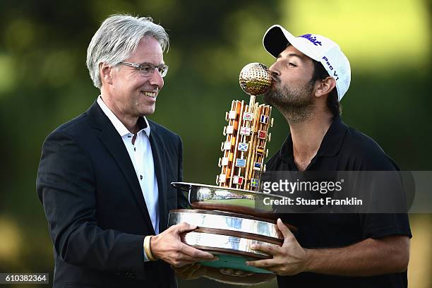 Andreas Haffner poses whilst Alexander Levy of France kisses the trophy after winning in the final round of the Porsche European Open at Golf Resort...