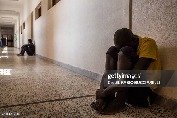 An African migrant coming from Ivory Coast rests at Libya's Karareem detention centre near Misrata, a town half-way between Sirte and Tripoli, on...