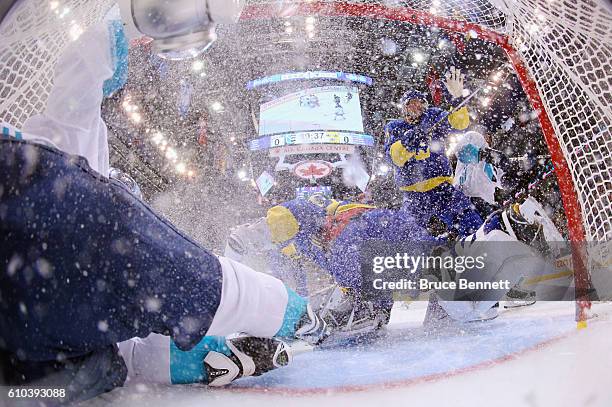 Tomas Tatar of Team Europe slides into the net past Henrik Lundqvist of Team Sweden during the first period at the semifinal game during the World...