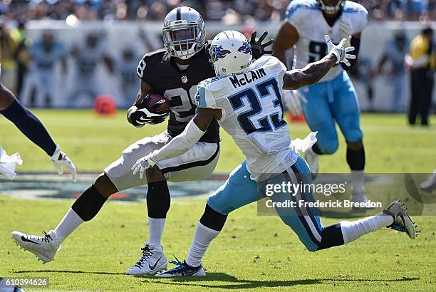 Latavius Murray of the Oakland Raiders rushes against Brice McCain of the Tennessee Titans during the first half at Nissan Stadium on September 25,...