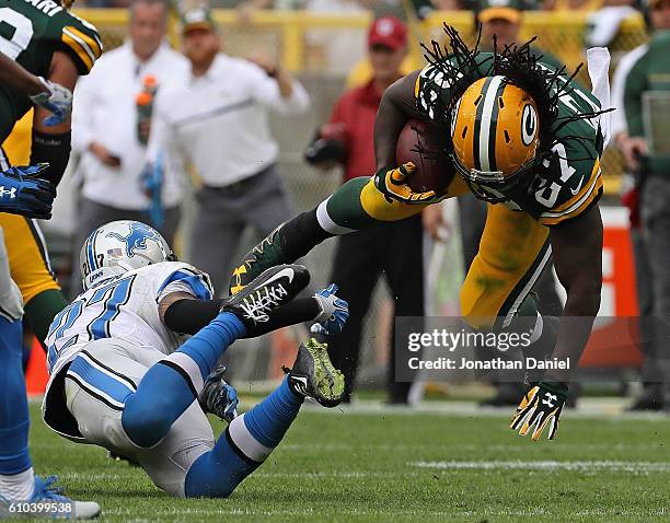 Eddie Lacy of the Green Bay Packers is upended by Glover Quin of the Detroit Lions at Lambeau Field on September 25, 2016 in Green Bay, Wisconsin.