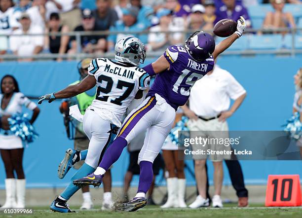 Robert McClain of the Carolina Panthers watches as Adam Thielen of the Minnesota Vikings makes a catch during their game at Bank of America Stadium...