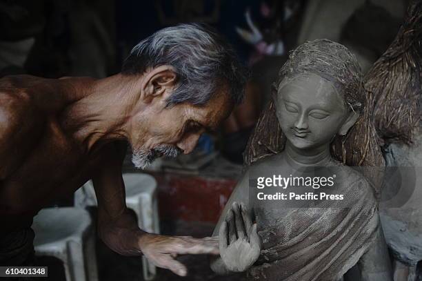 Bangladeshi artist works on a clay idol of Hindu goddess Durga in preparation for upcoming Durgapuja festival at a temple in Old Dhaka. Durga Puja is...