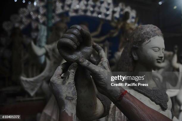 Bangladeshi artist works on a clay idol of Hindu goddess Durga in preparation for upcoming Durgapuja festival at a temple in Old Dhaka. Durga Puja is...