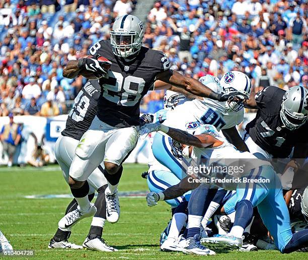 Latavius Murray of the Oakland Raiders breaks a tackle from Rashad Johnson of the Tennessee Titans opening him up to score a touchdown during the...
