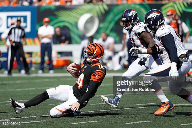 Andy Dalton of the Cincinnati Bengals slides while running upfield from Sylvester Williams of the Denver Broncos during the second half at Paul Brown...