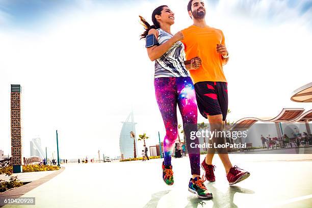 young couple running - fitness and exercising in dubai - arabische muster stockfoto's en -beelden