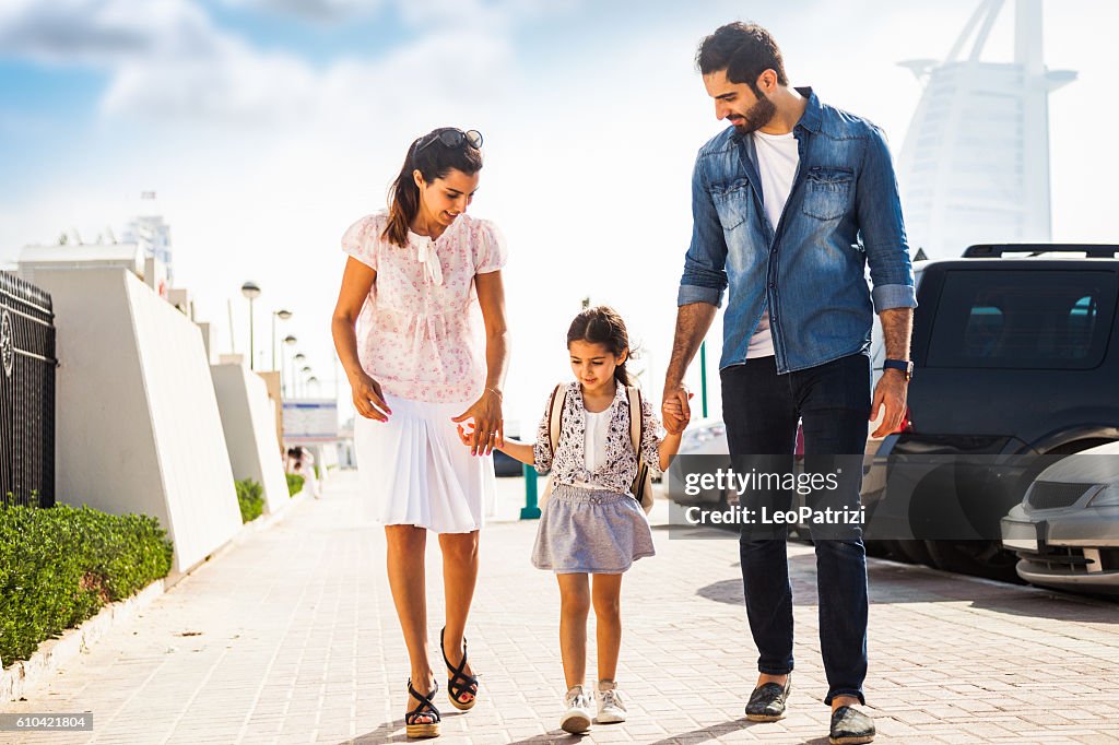 Young family taking daughter to school