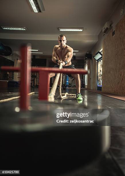 man pulling gym sled - pulling weight stock pictures, royalty-free photos & images