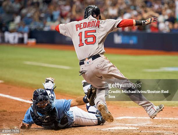 Dustin Pedroia of the Boston Red Sox avoids the tag of Curt Casali of the Tampa Bay Rays to score a go-ahead run in the tenth inning on September 25,...