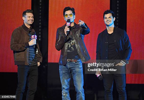 Host Ryan Seacrest and actors John Stamos and Taylor Lautner introduce a performance by Britney Spears at the 2016 iHeartRadio Music Festival at...