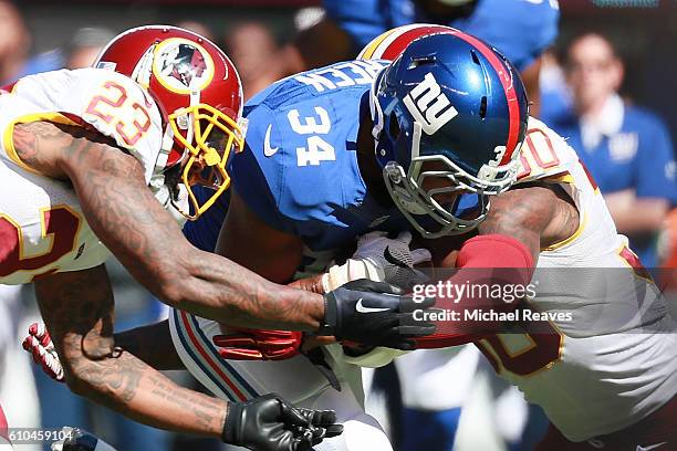 Shane Vereen of the New York Giants is tackled by DeAngelo Hall and David Bruton of the Washington Redskins in the first half at MetLife Stadium on...