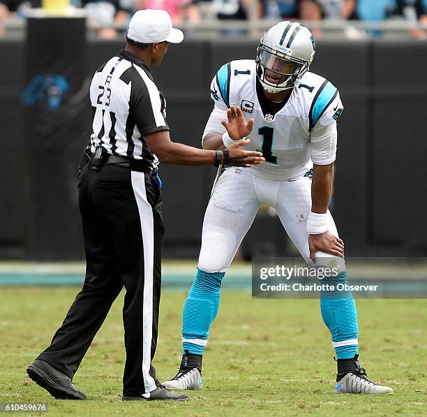 Carolina Panthers quarterback Cam Newton tries to negotiate with referee Jerome Boger on not to leave the game after having his ankle twisted while...
