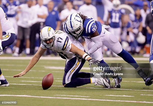 Philip Rivers of the San Diego Chargers fumbles the ball after being tackled by Erik Walden of the Indianapolis Colts during the game at Lucas Oil...